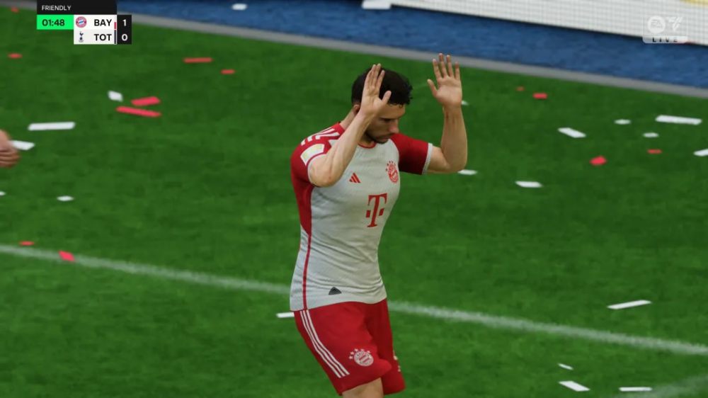 Leon Goretzka wearing a white and red Bayern Munich shirt with his hands in the air. 