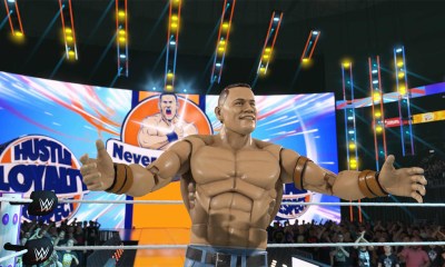 Elite Mattel John Cena doing his entrance, standing in front of his titantron with his arms spread out.