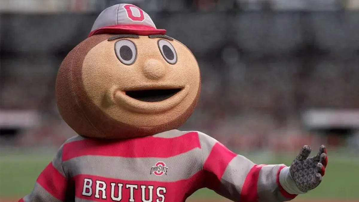 Ohio State's Brutus Buckeye Mascot standing with his hand extended out.