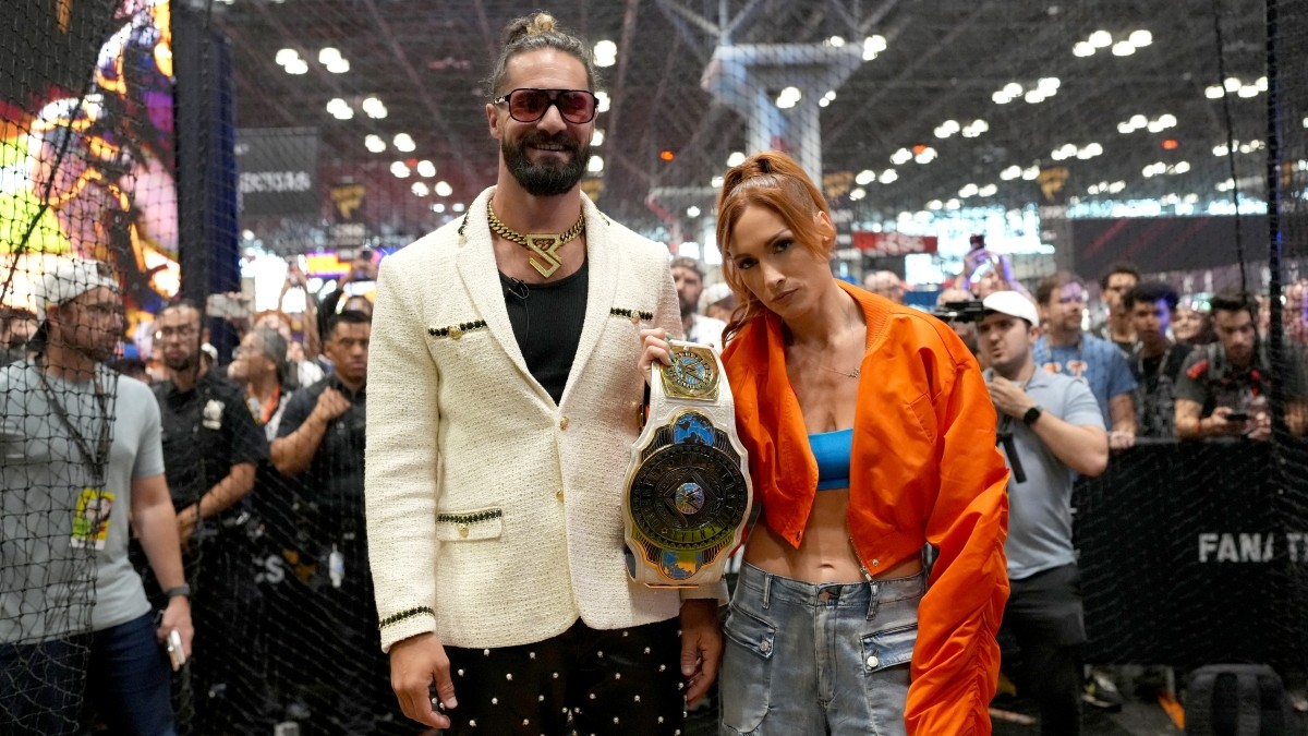 WWE stars Becky Lynch and Seth Rollins standing together 